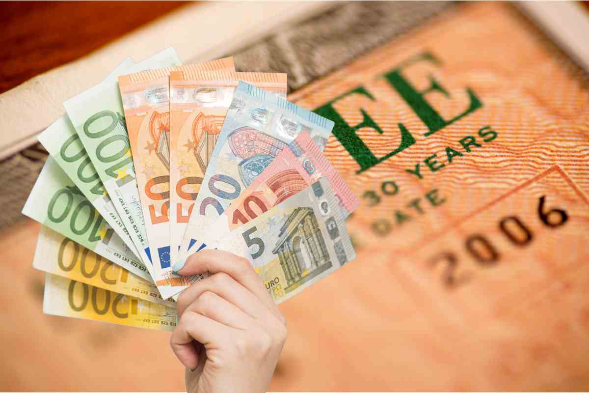 Buono fruttifero e soldi in euro in una mano