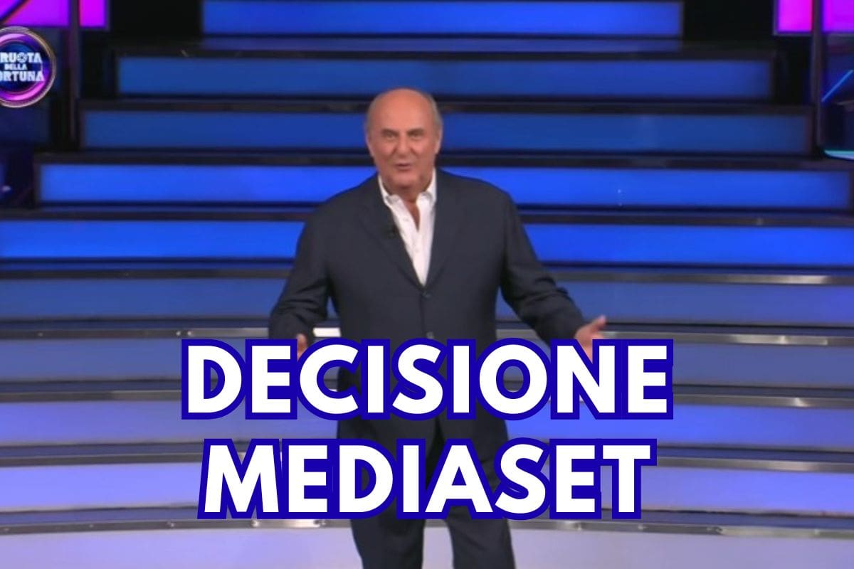 gerry scotti con scritta decisione mediaset