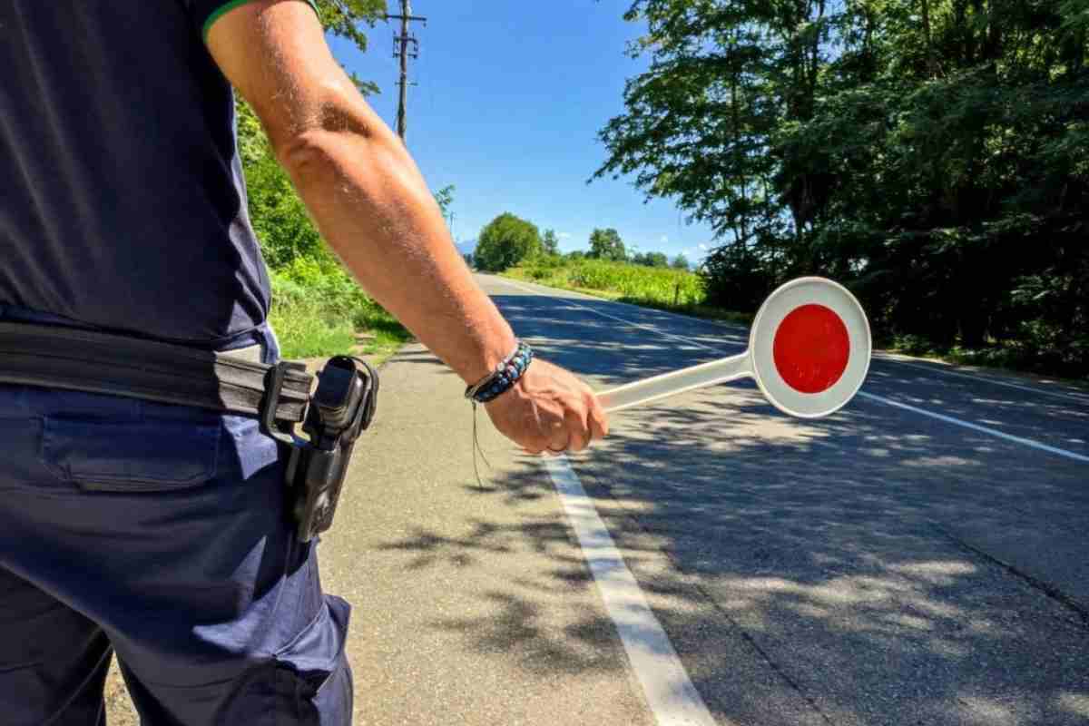 Un agente con paletta al posto di blocco