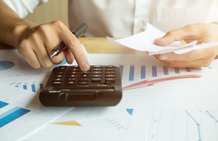 Persona che fa dei calcoli con la calcolatrice 