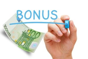 mano che scrive BONUS e banconota da 100€