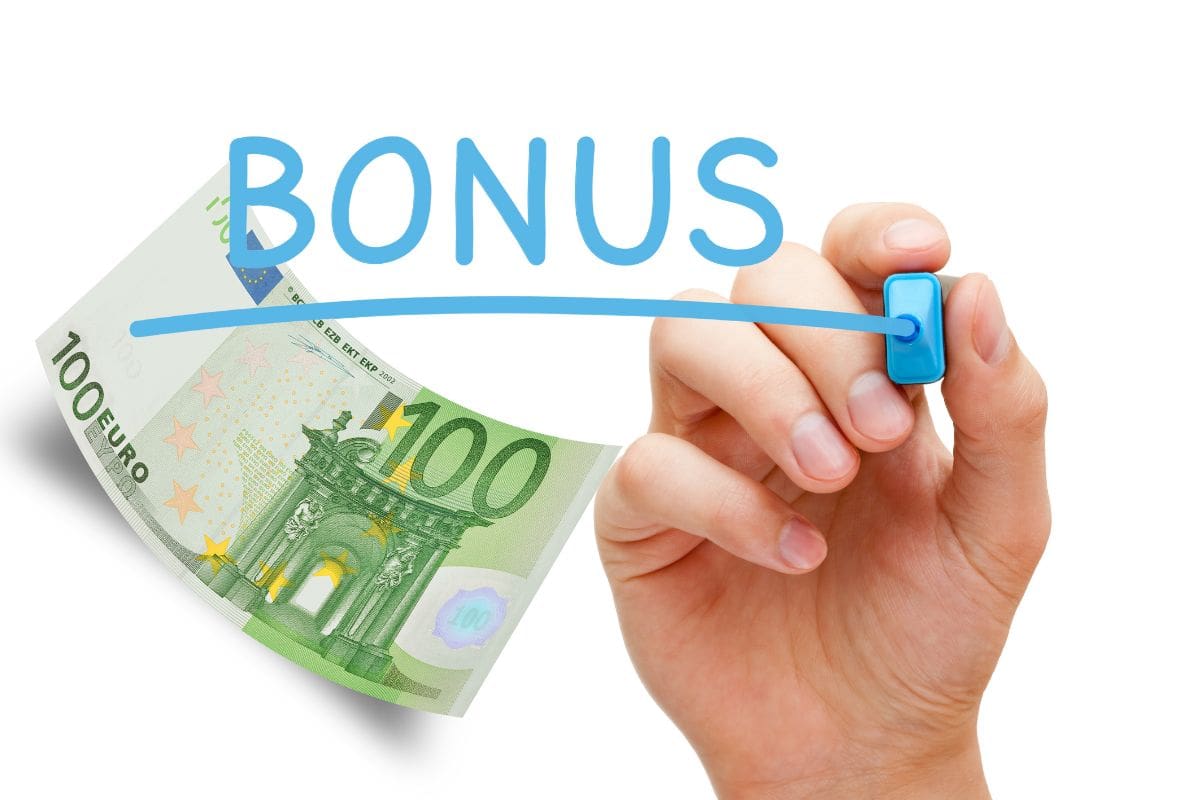 mano che scrive BONUS e banconota da 100€