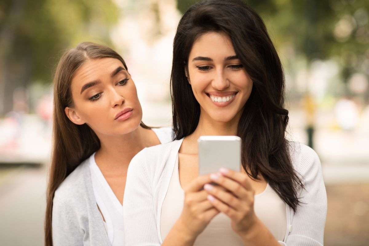 Ragazza sbircia smartphone dell'amica