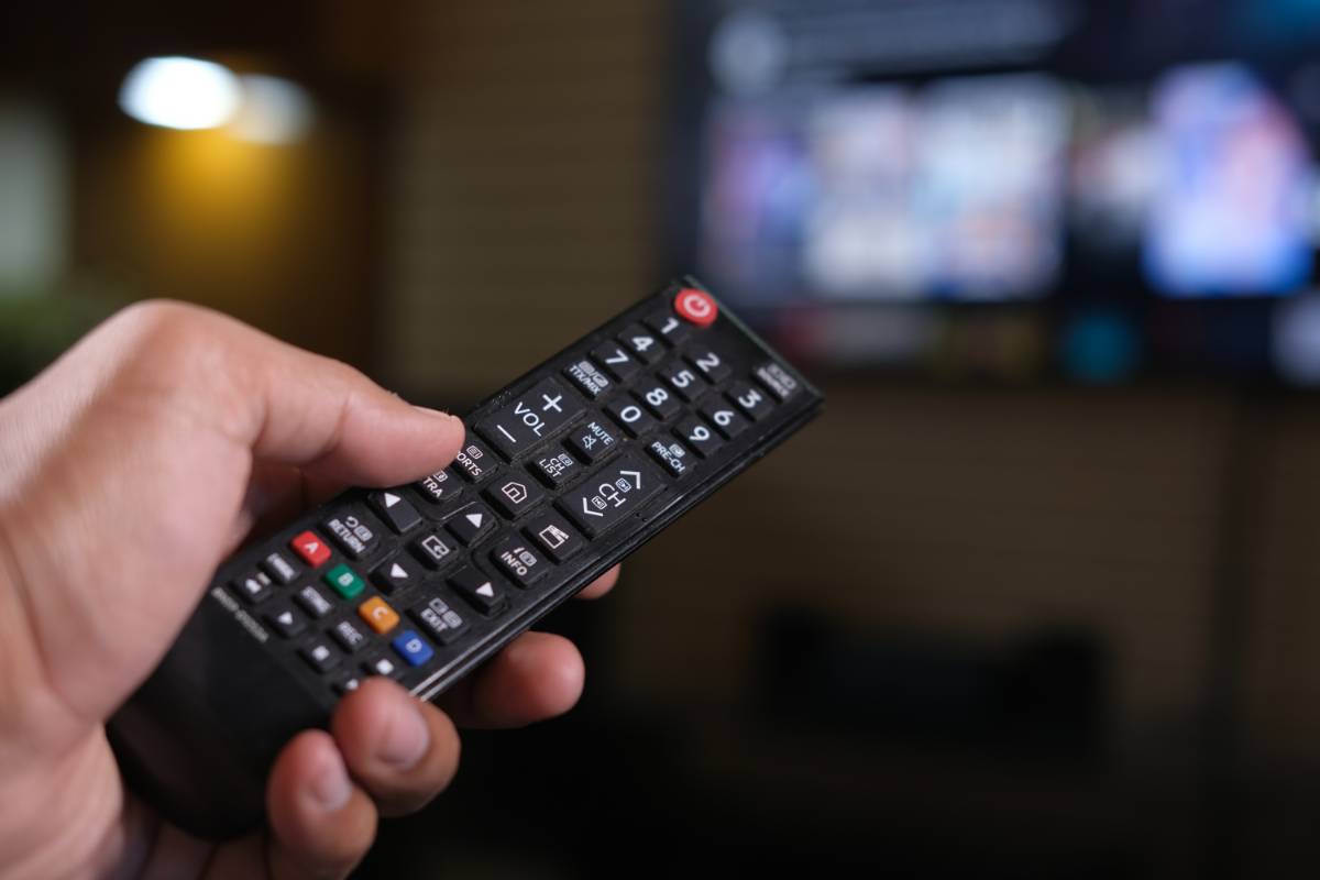 persona con telecomando tv in mano