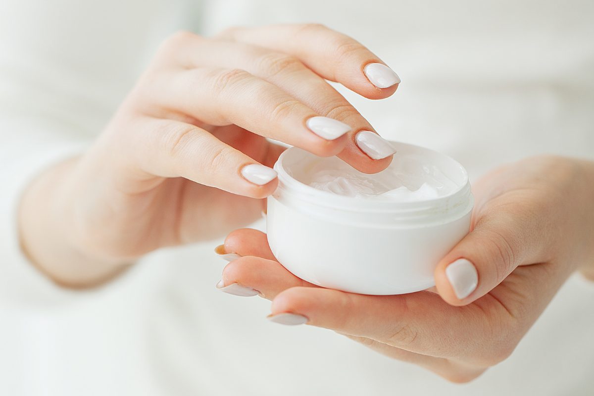donna con vasetto di crema in mano